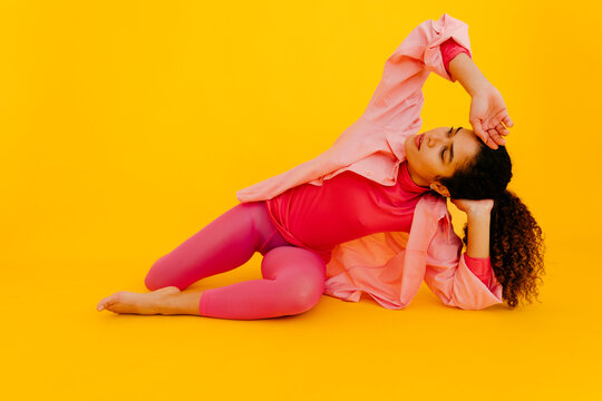 Woman With Head In Hand Against Yellow Background