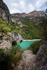 Obraz premium Deep turquoise river at the bottom of a vertical canyon with people kayaking.