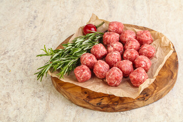 Raw uncooked beef meatballs served rosemary