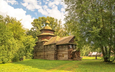 Fototapeta na wymiar Summer landscape with an old log church on a lawn in the forest