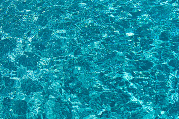 Background of blue water in swimming pool with sun reflection, ripple water wave in pool. Clear water background.