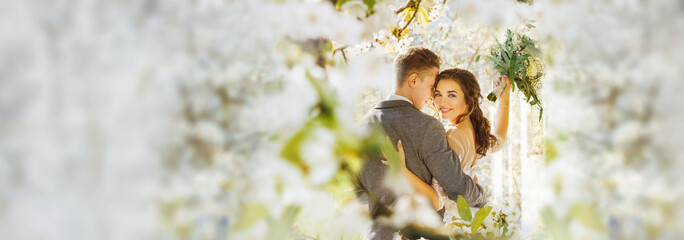 Amazing smiling wedding couple. Pretty bride and stylish groom posing and kisses. Flowery Romantic...