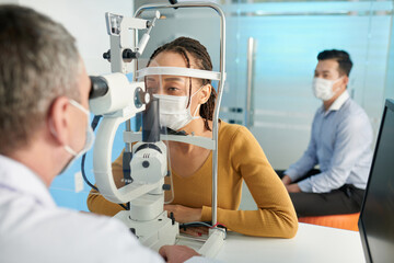 Fototapeta na wymiar Young woman getting intraocular pressure measured in medical office of optometrist