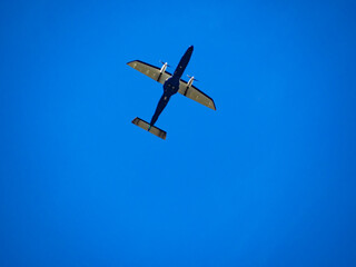 青空を悠々と飛ぶ小型飛行機