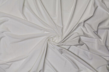 White crumpled or wavy fabric texture background. Abstract linen cloth soft waves. Creases of satin, silk, and cotton. Smooth elegant silk or atlas luxury cloth texture. Bedding Sheets or blanket.