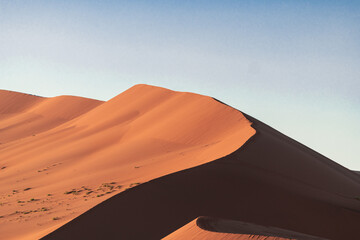 Fototapeta na wymiar Sharp contrast between 2 dunas sides- light and shadow, Namibia.