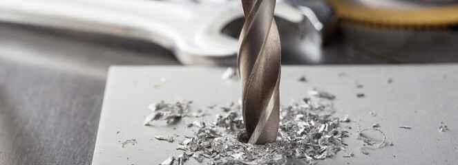 metal drill bit make holes in aluminium plate on industrial drilling machine. Metal work industry. - obrazy, fototapety, plakaty