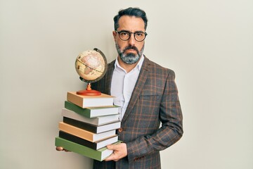 Middle age man with beard and grey hair teacher holding vintage world ball depressed and worry for...