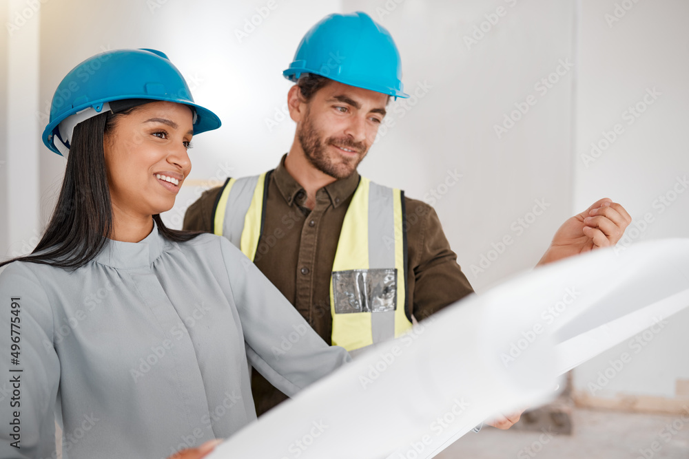 Poster lets get building. shot of two young architects looking at building plans on site.