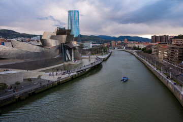Panoramic view of the Nervión river and the Guggenheim museum on a cloudy day, of the city in Bilbao, Spain, 04-05-2022