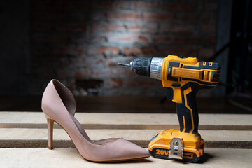 Women's beige boat shoe with a heel and a drill-driver on a surface of wooden slats against a background of a brick wall