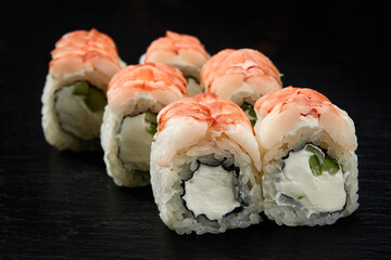 Sushi rolls Philadelphia with snow crab, cream cheese, cucumber, sesame seeds isolateed on black background. Japanese oriental cuisine