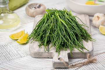 Cooking Fresh Agretti or barba dei frati, edible green plant. Saltwort, barilla plant or salsola soda.