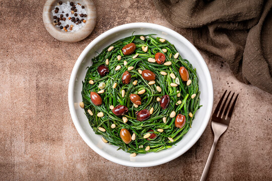 Italian Salad with Sauteed Agretti or barba di frati with garlic, Taggiasca olives, pinoli or pine nut. Top table view.