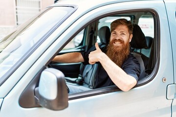 Young irish man smiling happy driving car doing ok sign with thumb up at the city.