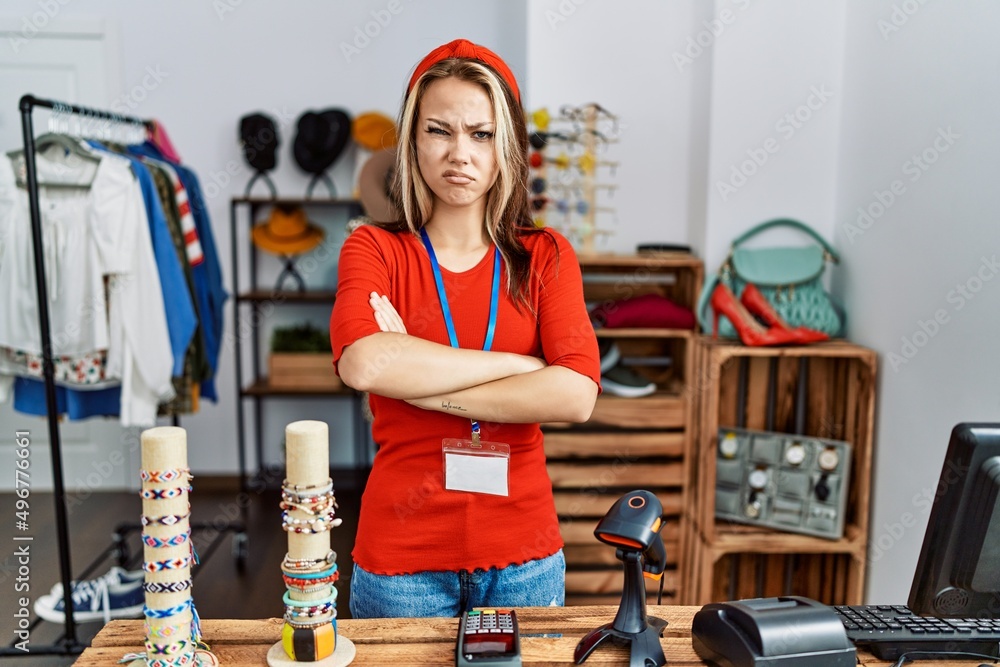 Sticker Young caucasian woman working as manager at retail boutique skeptic and nervous, disapproving expression on face with crossed arms. negative person.