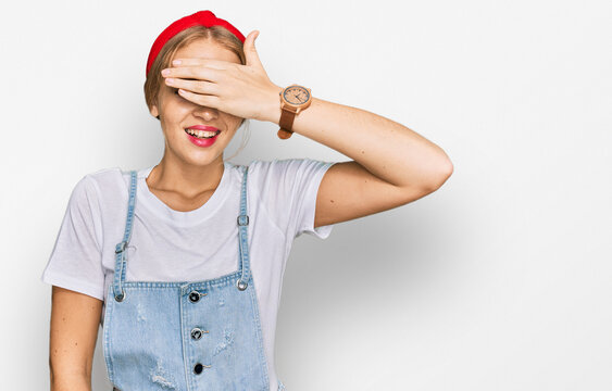 Young caucasian girl wearing casual clothes smiling and laughing with hand on face covering eyes for surprise. blind concept.