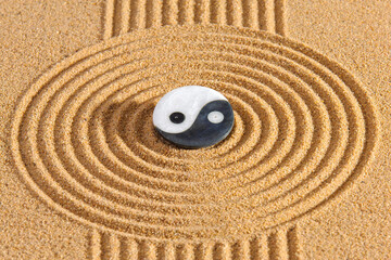 Japanese zen garden with yin and yang and feng shui in textured sand
