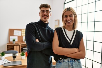 Obraz premium Two beautiful business workers wearing business style standing at the office happy face smiling with crossed arms looking at the camera. positive person.
