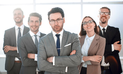 Happy business team with arms crossed at the office