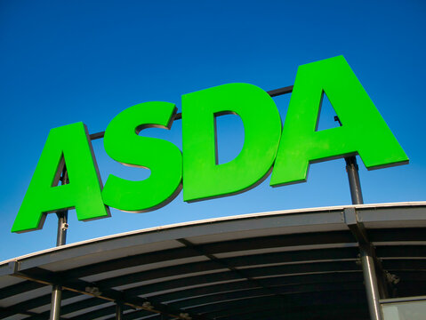 Corporate signage at a store of the ASDA British supermarket chain. Taken against a cloudless, blue sky on a sunny day.