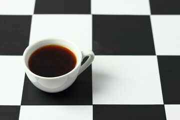 A cup of coffee on a chessboard.