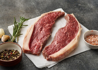 Picanha raw organic  beef steaks with seasoning over rustic dark background. Rump cap steak
