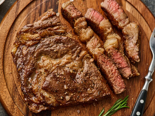 Medium rare Ribeye steak or beef steak on the wooden tray with herbs
