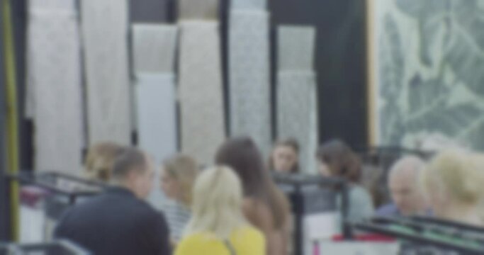 silhouettes of unrecognizable people who choose fabrics in the store.blurred defocused video.