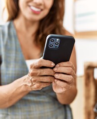 Young latin woman business worker using smartphone at office