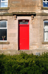 Naklejka premium Red Painted Entrance Door to Old Stone Building 