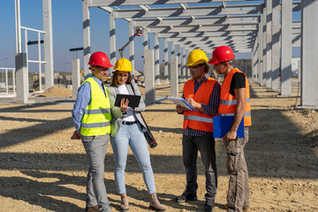 Construction Project Manager And His Team Discuss A Project On Construction Site. Project Management and Field Crew Meeting on Site. Supervisor, Female Architect , Foreman and Construction Worker.