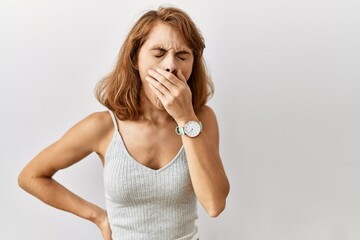 Beautiful caucasian woman standing over isolated background bored yawning tired covering mouth with hand. restless and sleepiness.