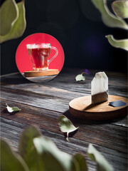 A dry, clean tea bag stands on a pedestal and looks into the mirror. In the mirror there is a mug of hot freshly brewed tea with steam.
Advertising shooting concept. Concept before and after. 