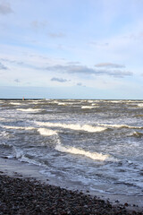 Fototapeta na wymiar Baltic sea shoreside view with waves and cloudy weather.