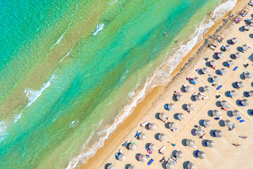 Top view aerial drone photo of Banana beach with beautiful turquoise water, sea waves and straw umbrellas. Vacation travel background. Ionian sea, Zakynthos Island, Greece