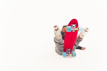 Ups Accidents happen little boy falls off red mini skateboard over white background. Isolated studio shot. High quality photo