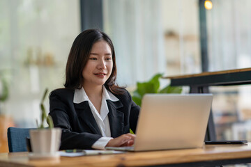 Portrait of smiling beautiful business asian woman working in office use computer with copy space. Business owner people sme freelance online marketing e-commerce telemarketing, work from home concept