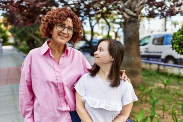 Fototapeta premium Mature mother and down syndorme daughter smiling happy and friendly outdoors