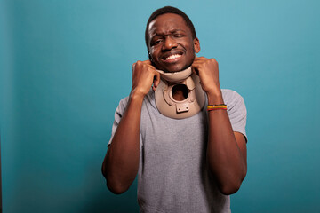Injured person wearing cervical collar to recover from fracture accident, feeling upset about...