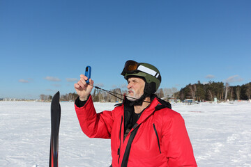 Man in a red jacket measures the wind speed with an anemometer in winter, Novosibirsk, Russia