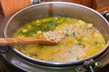 A large thermos contains fresh soup for donation to the poor