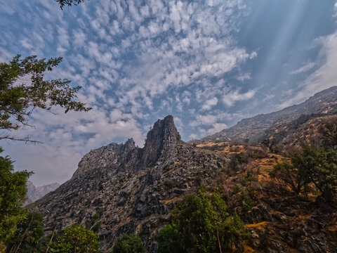 View of Boyden Cavern surrounded by rocks and trees under blue bright sky in Sequoia National Park