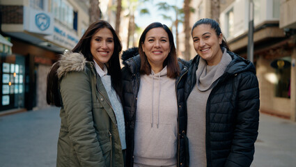 Mother and daugthers smiling confident hugging each other at street