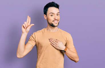 Hispanic man with beard wearing casual t shirt smiling swearing with hand on chest and fingers up,...
