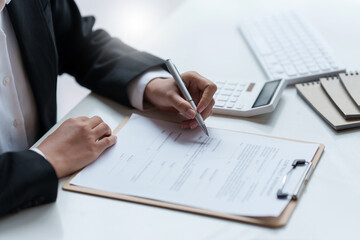 Close up of Business woman pointing and signing agreement for buying house. Bank manager concept.