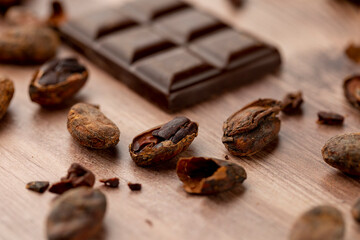 Dark chocolate bar close up photography with roasted cocoa beans
