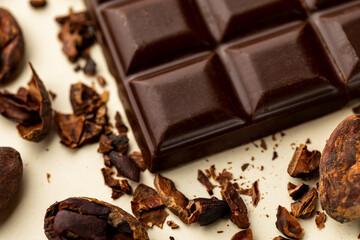 Dark chocolate bar close up photography with roasted cocoa beans