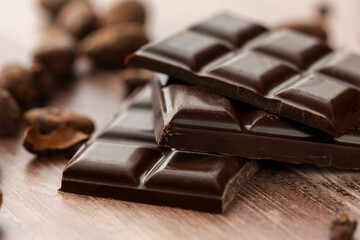 Dark chocolate bar close up photography with roasted cocoa beans