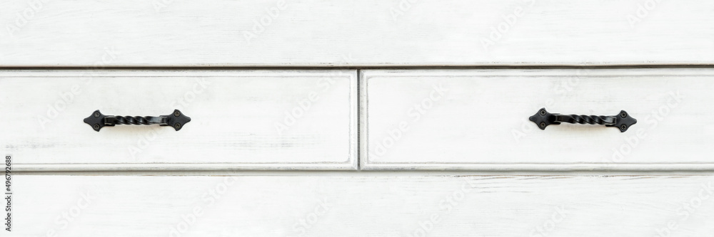 Wall mural White wooden drawers front with forged metal handles, panoramic, banner. Aged painted furniture with retro design.